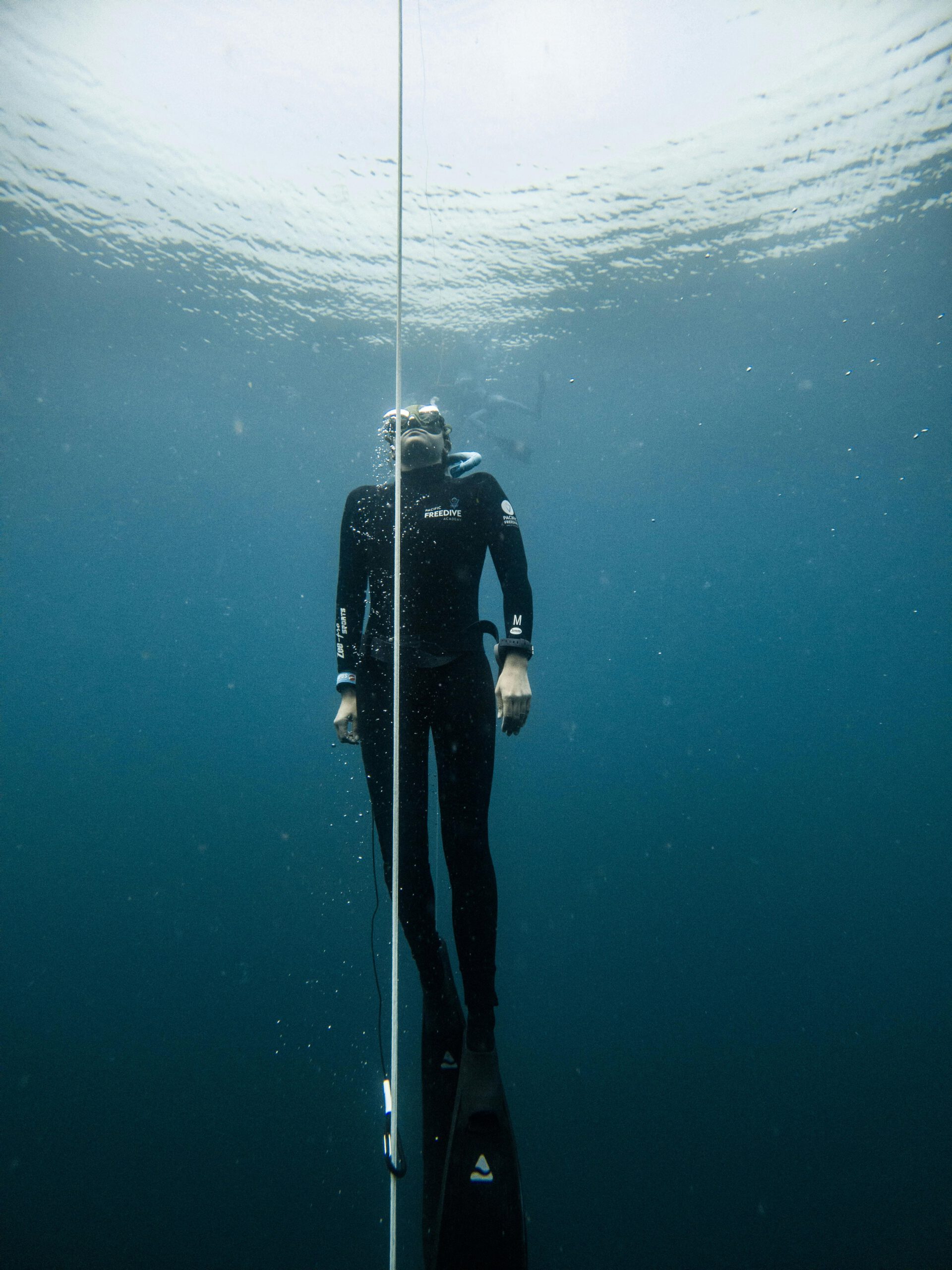 A freediver descends into the deep blue waters of Lombok, Indonesia, showcasing underwater exploration.